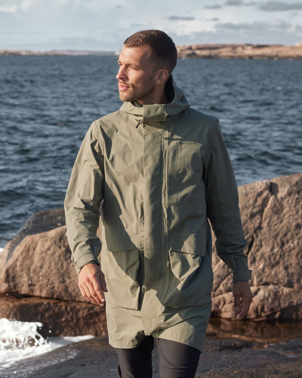 Deep-green Coloured Didriksons Andreas Unisex Parka 2 On A Coastal Background 