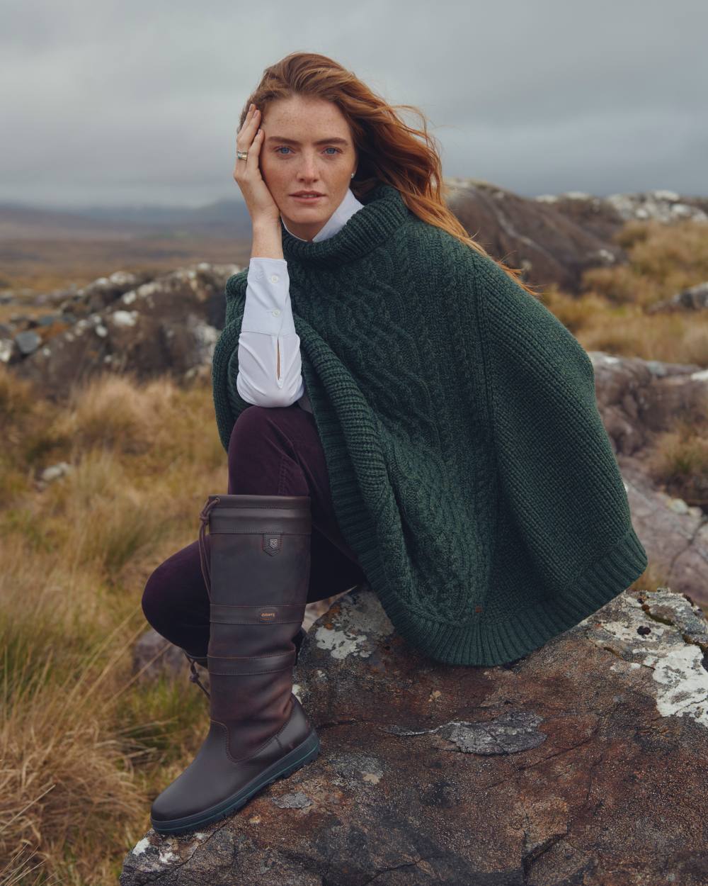 Olive Coloured Dubarry Womens Kilronan Merino Poncho On A Hill Background 