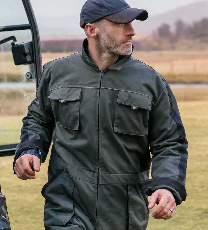 Farmers overalls and boilersuits. Farmer wears green boilersuit with twin chest pockets.