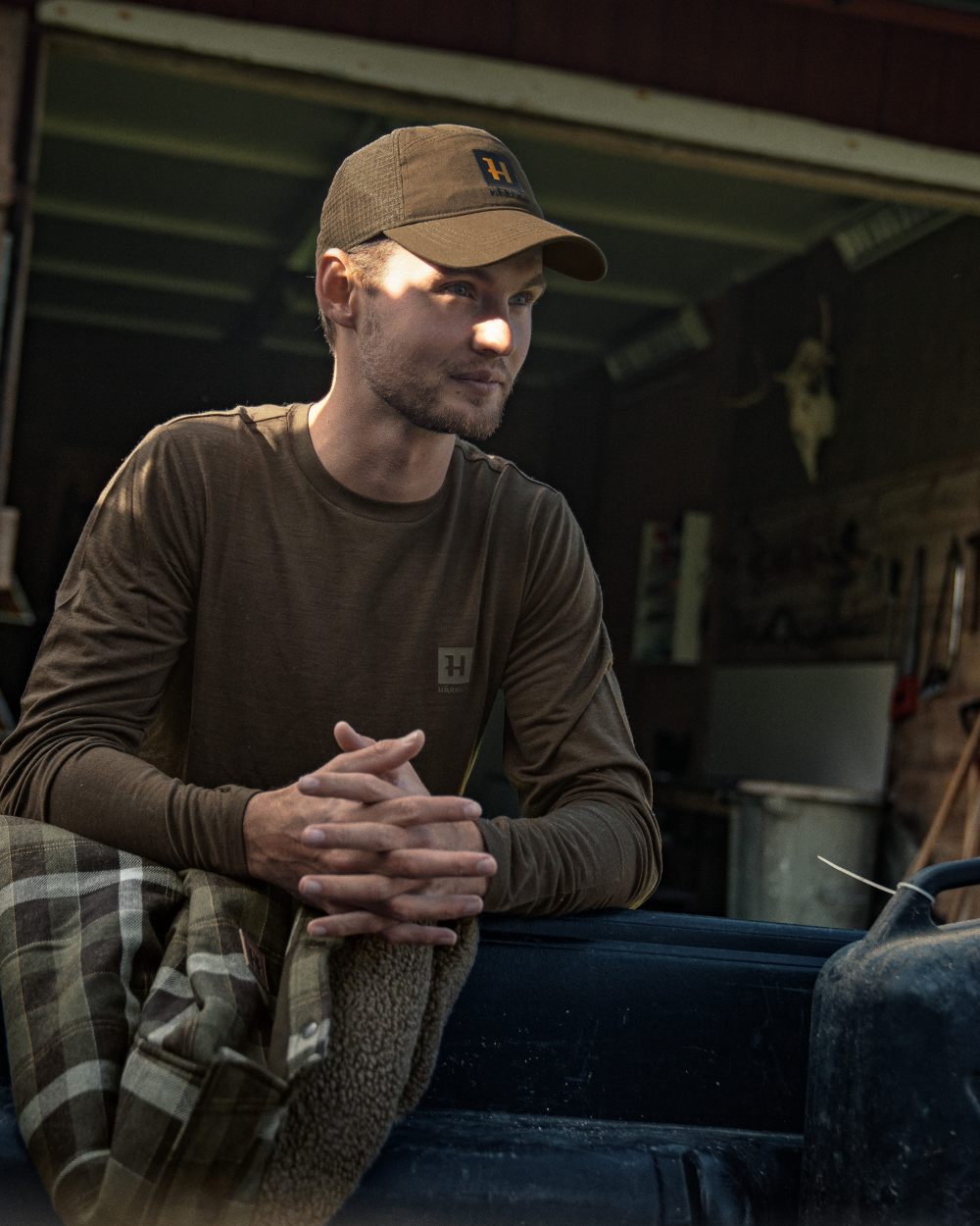 Shadow Brown Coloured Harkila Base All Season Long Sleeve T-Shirt On A Backyard Background 