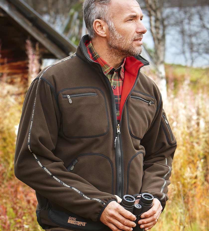 Harkila waterproof hunting fleece in green worn by man with binoculars.