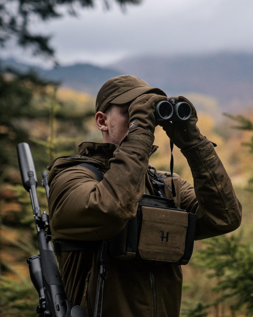 Hunting Green Shadow Brown Coloured Harkila Forest Hunter GTX Jacket On A Forest Background