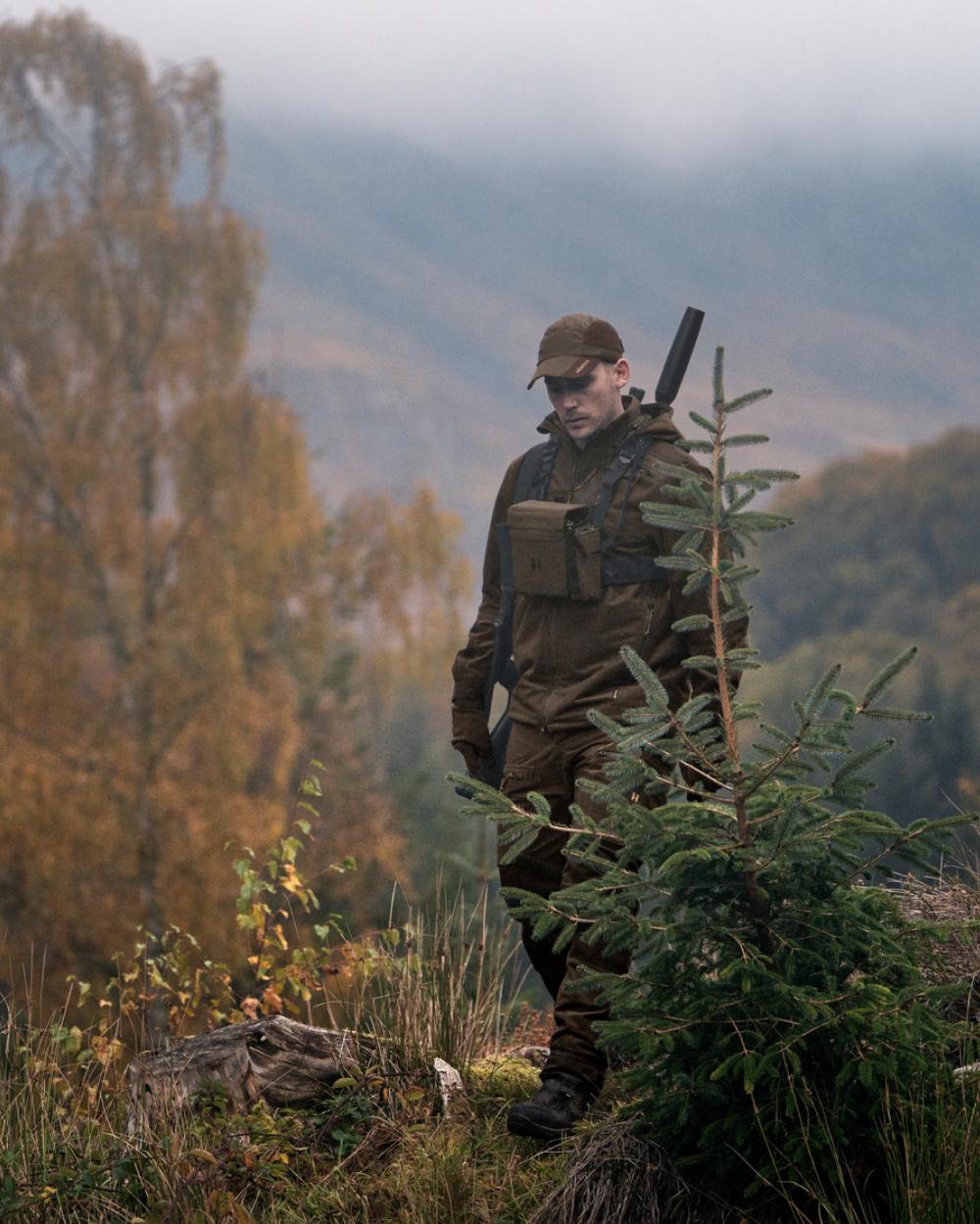 Hunting Green Shadow Brown Coloured Harkila Forest Hunter GTX Jacket On A Forest Background