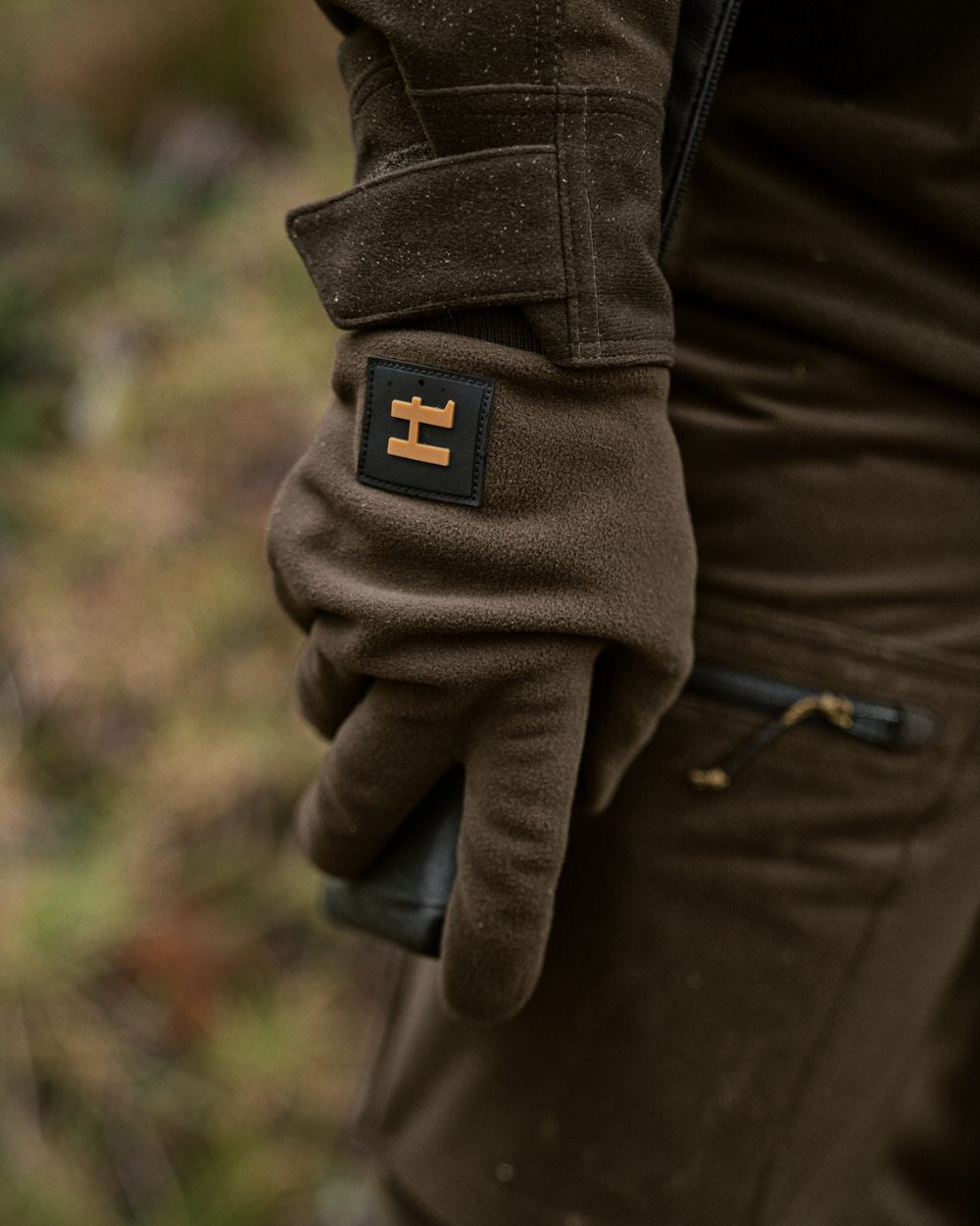 Hunting Green Shadow Brown Coloured Harkila Forest Hunter WSP Gloves On A Forest Background