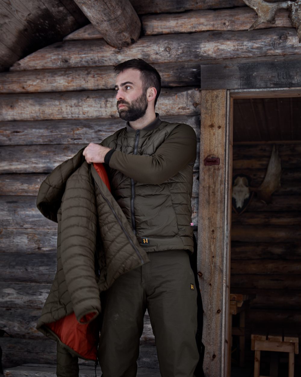 Willow Green Coloured Harkila Logmar Insulated Packable Waistcoat On A Woody House Background