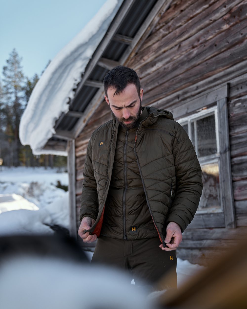 Willow Green Coloured Harkila Logmar Insulated Packable Waistcoat On A Woody House Background