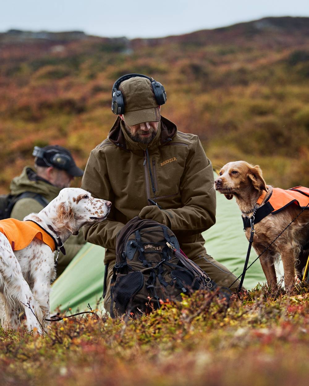 Hunting Green Shadow Brown Coloured Harkila Mountain Hunter Jacket On A Forest Background