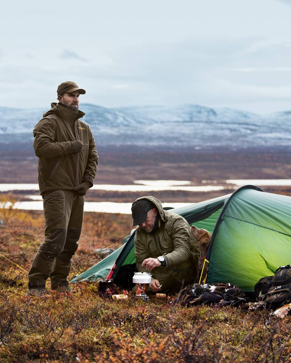 Hunting Green Shadow Brown Coloured Harkila Mountain Hunter Jacket On A Forest Background