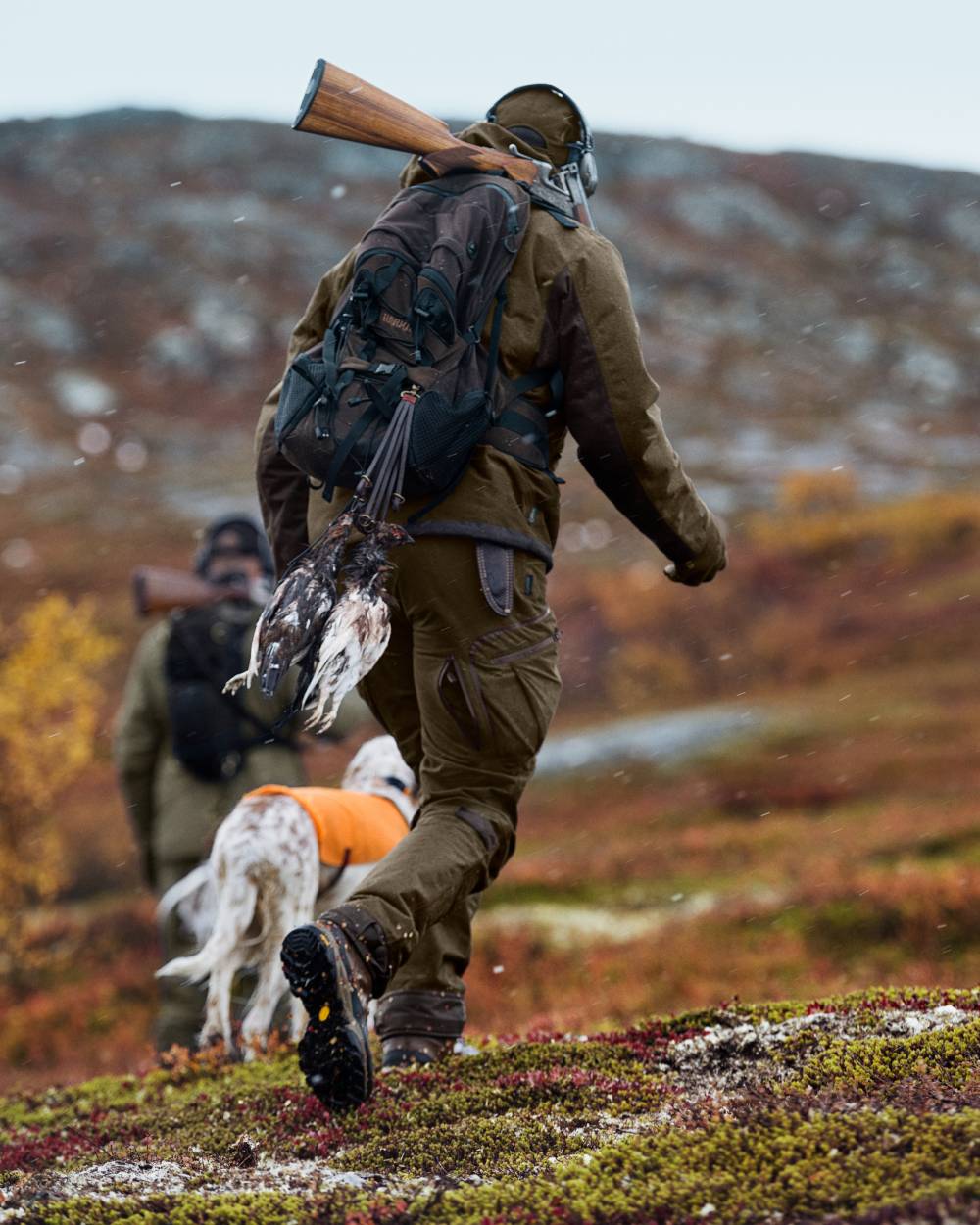 Hunting Green Shadow Brown Coloured Harkila Mountain Hunter Jacket On A Forest Background