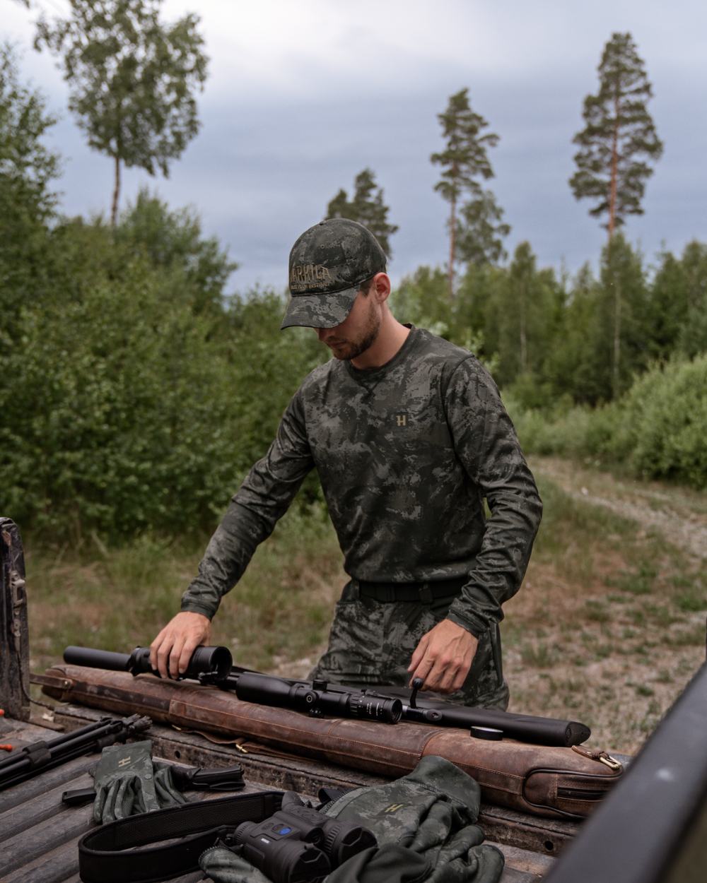 Axis Black Coloured Harkila NOCTYX Camo Long Sleeve T-Shirt On A Forest Background