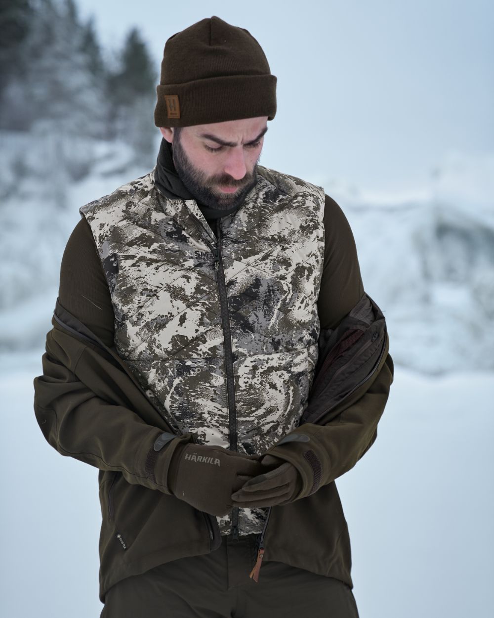 AXIS Mountain Coloured Harkila Camo HSP Insulated Waistcoat on snow background 