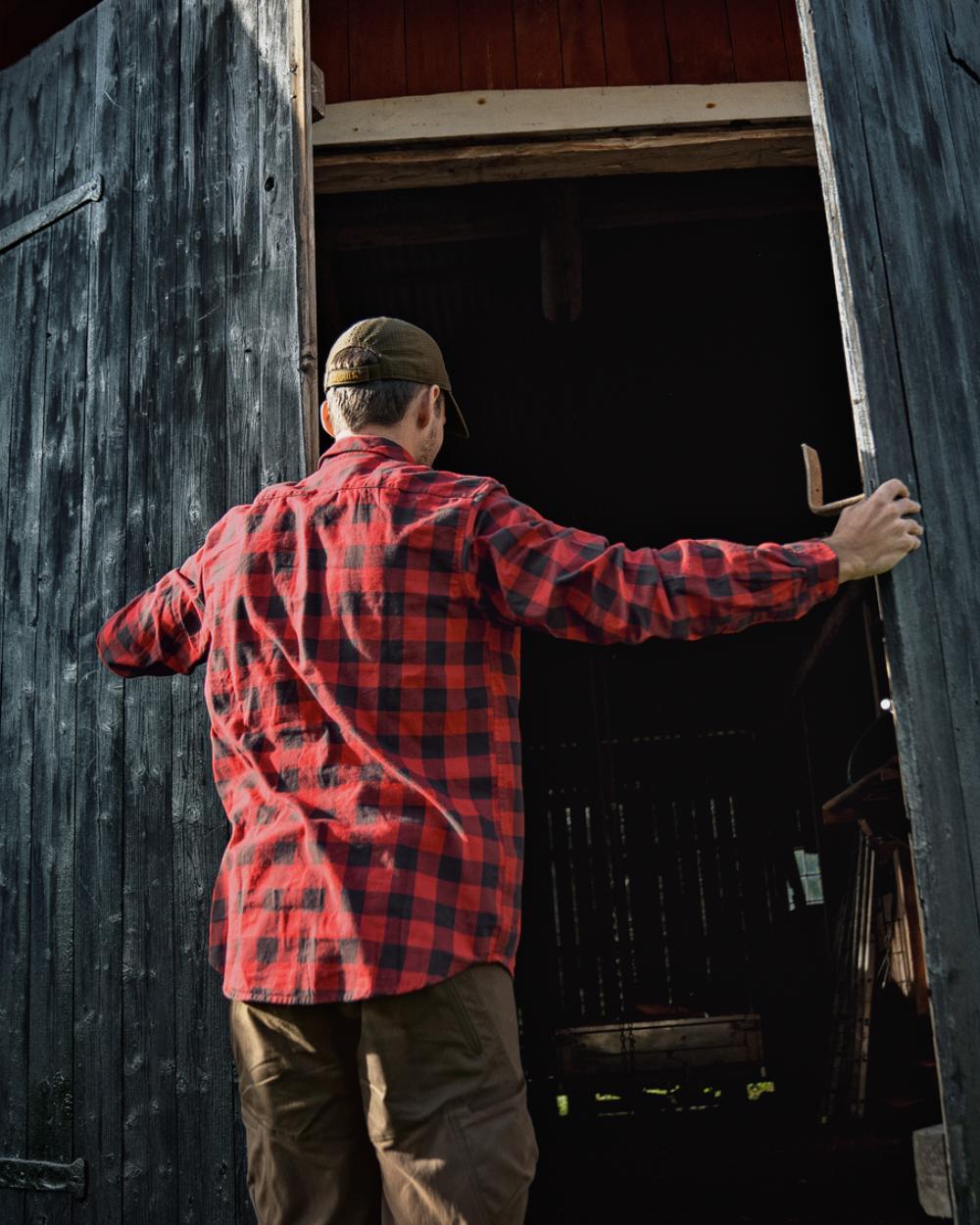 Red Check Coloured Harkila Scandinavian Long Sleeve Shirt On A Backyard Background 