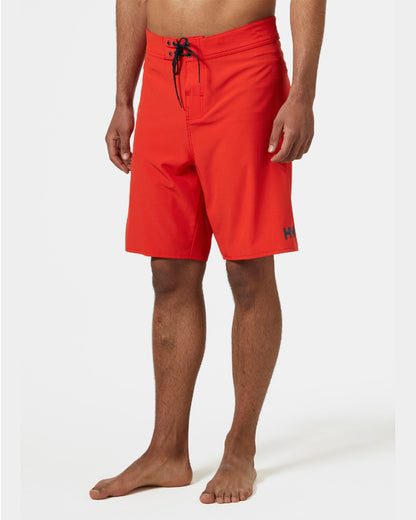 Alert Red Coloured Helly Hansen Mens HP 9 inch Board Shorts 3.0 on grey background 
