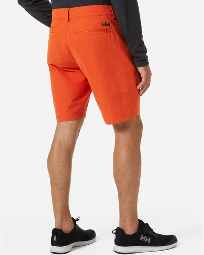 Patrol Orange coloured Helly Hansen Mens HP Quick Dry 10 inch Club Shorts 2.0 on grey background 