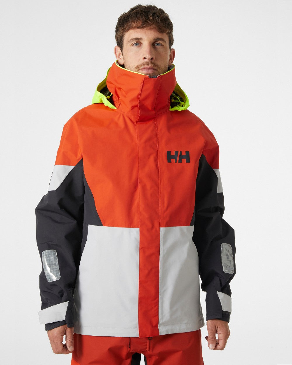 Patrol Orange coloured Helly Hansen Mens Newport Regatta Jacket on grey background 