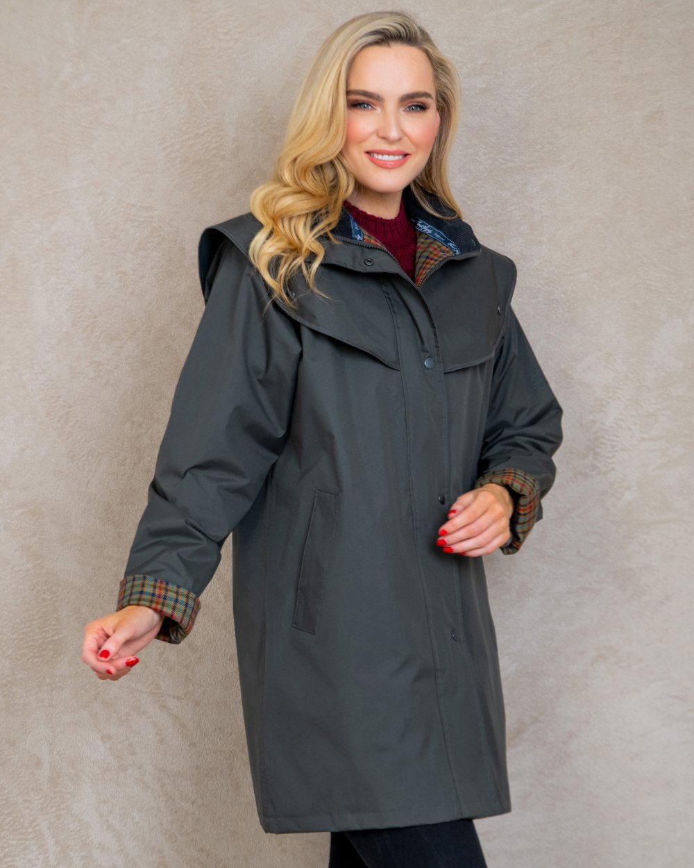 Olive coloured Jack Murphy Cotswold Ladies Waterproof 3/4 Coat on wall background 