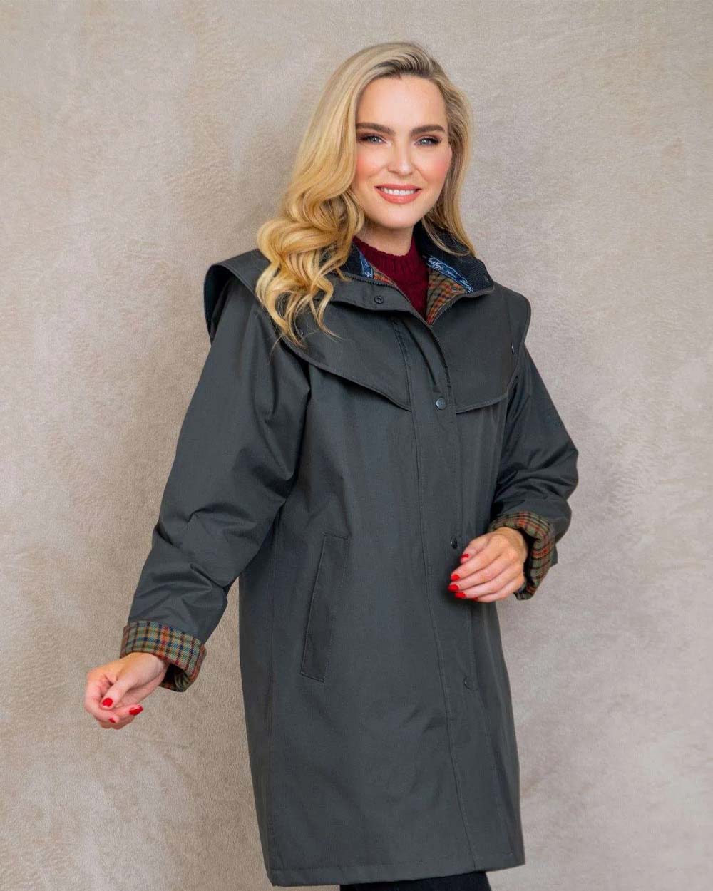 Olive coloured Jack Murphy Cotswold Ladies Waterproof 3/4 Coat on wall background 