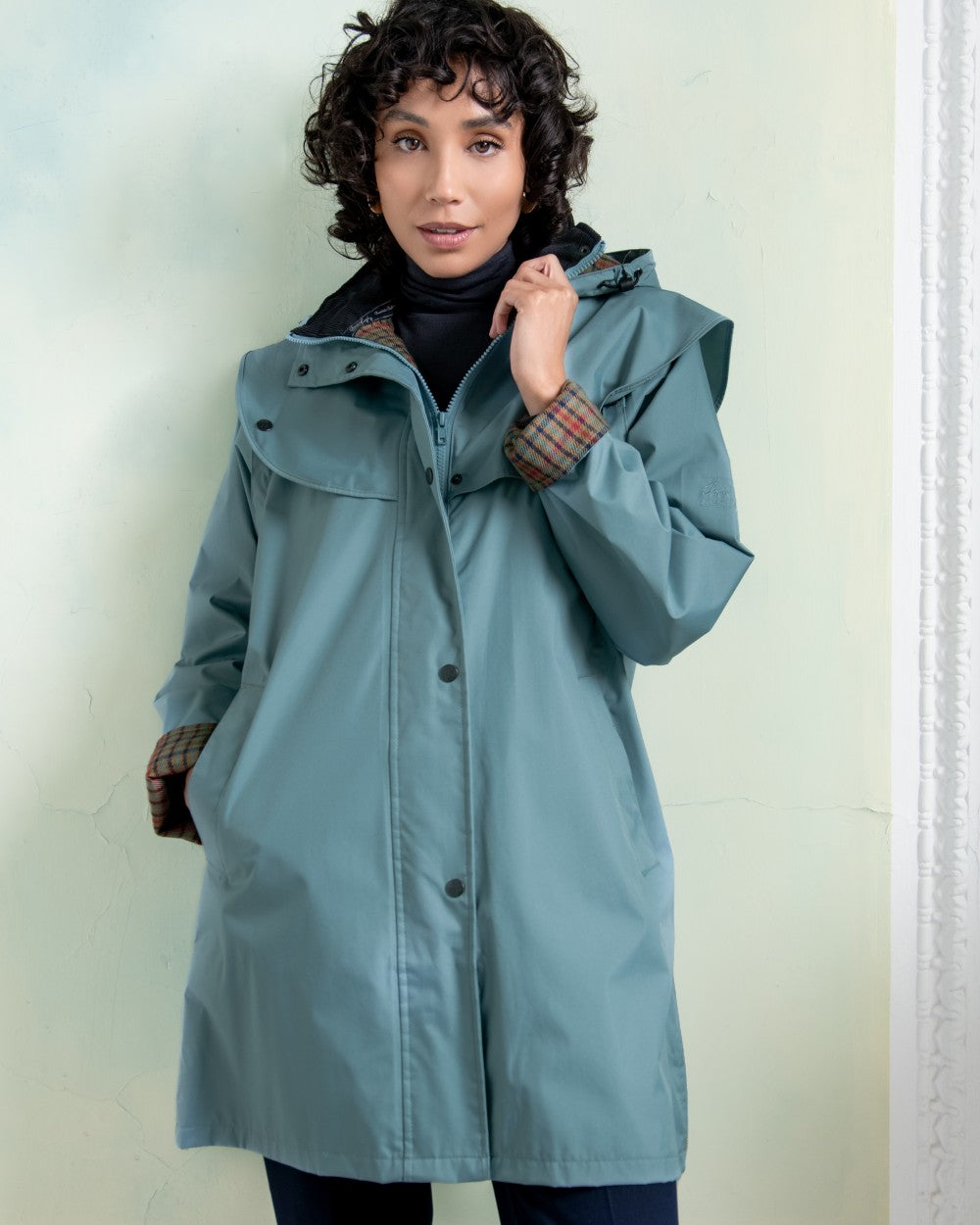 Smoke Blue coloured Jack Murphy Cotswold Ladies Waterproof 3/4 Coat on Teal background 