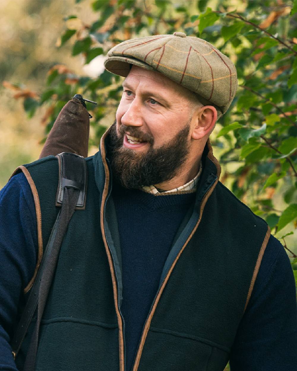 Tweed Green Coloured Jack Pyke Wool Blend Tweed Flat Cap On Leafy Background 