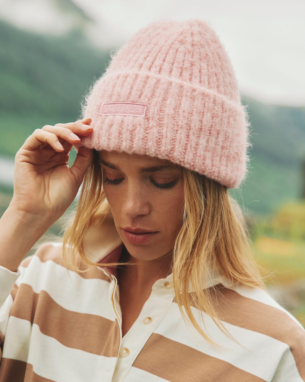 Pink Coloured Joules Caversham Beanie On A Street Background 