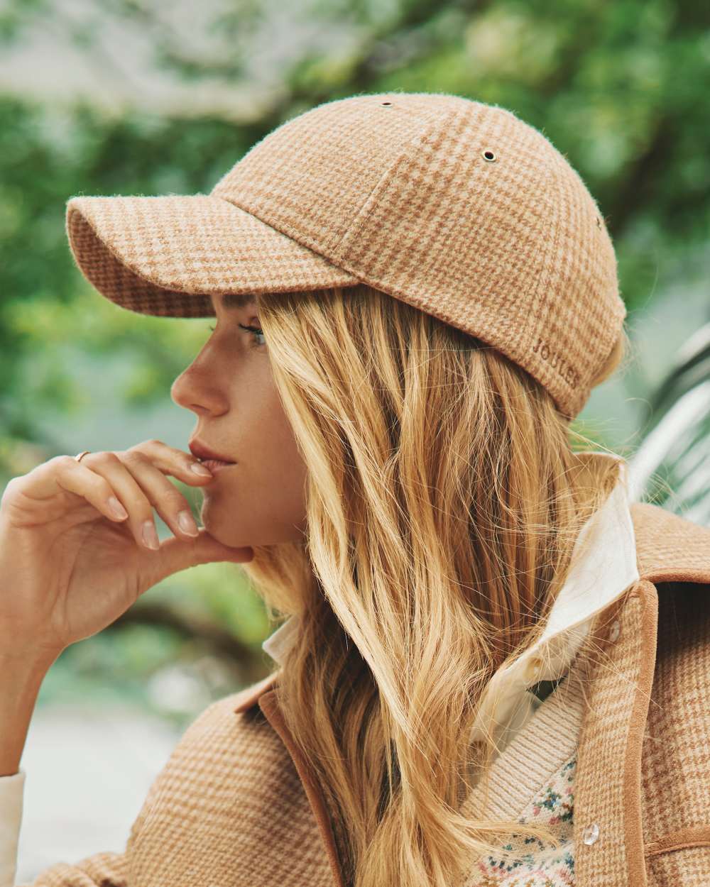 Neutral Coloured Joules Daley Check Cap On A Street Background 