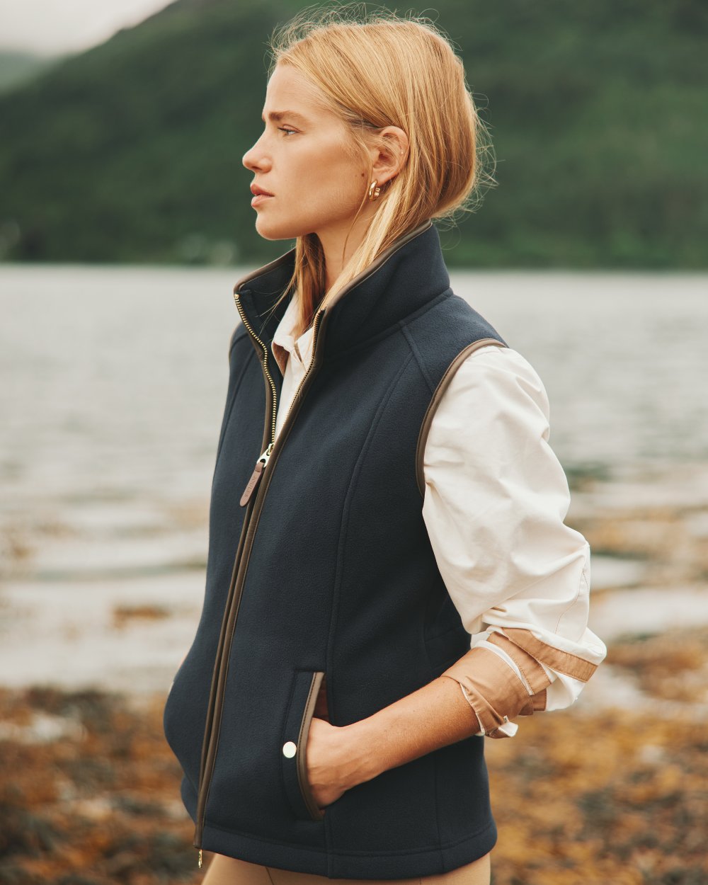 Navy coloured Joules Fairbourne Fleece Gilet on coastal background 