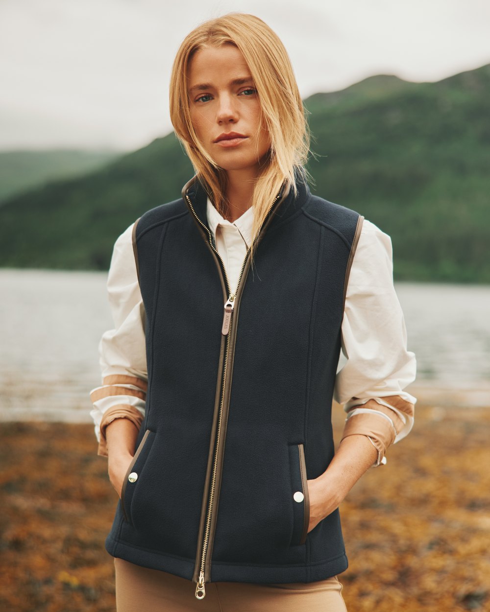 Navy coloured Joules Fairbourne Fleece Gilet on coastal background 