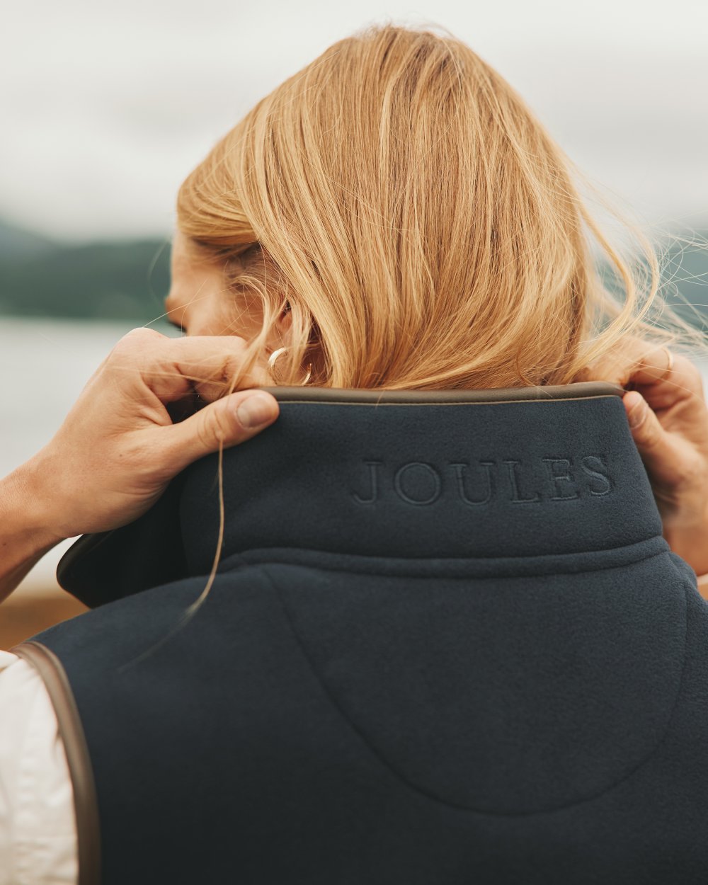 Navy coloured Joules Fairbourne Fleece Gilet on coastal background 
