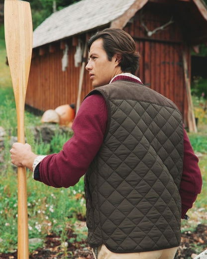 Brown Coloured Joules Gibson Quilted Lightweight Gilet On A Forest Background 