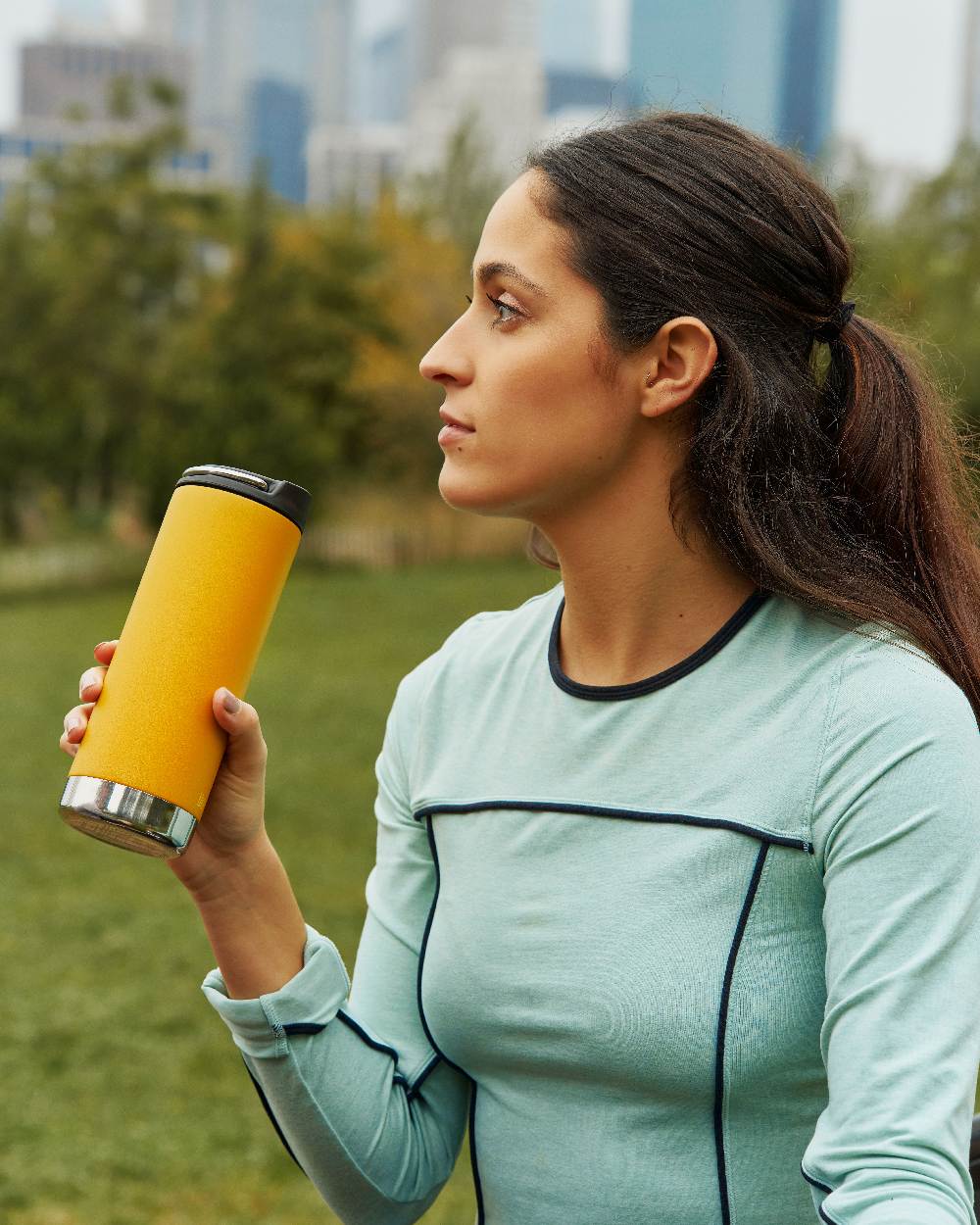 Marigold Coloured Klean Kanteen Insulated TKWide With Cafe Cap On A Garden Background 