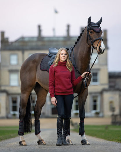 Ember Coloured LeMieux Adele Funnel Neck Sweatshirt On A Outer Yard Background 