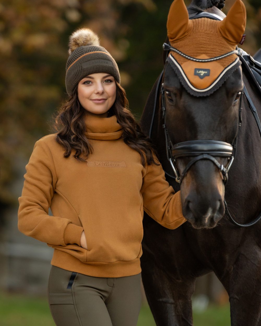 Ginger Coloured LeMieux Adele Funnel Neck Sweatshirt On A Outer Yard Background 