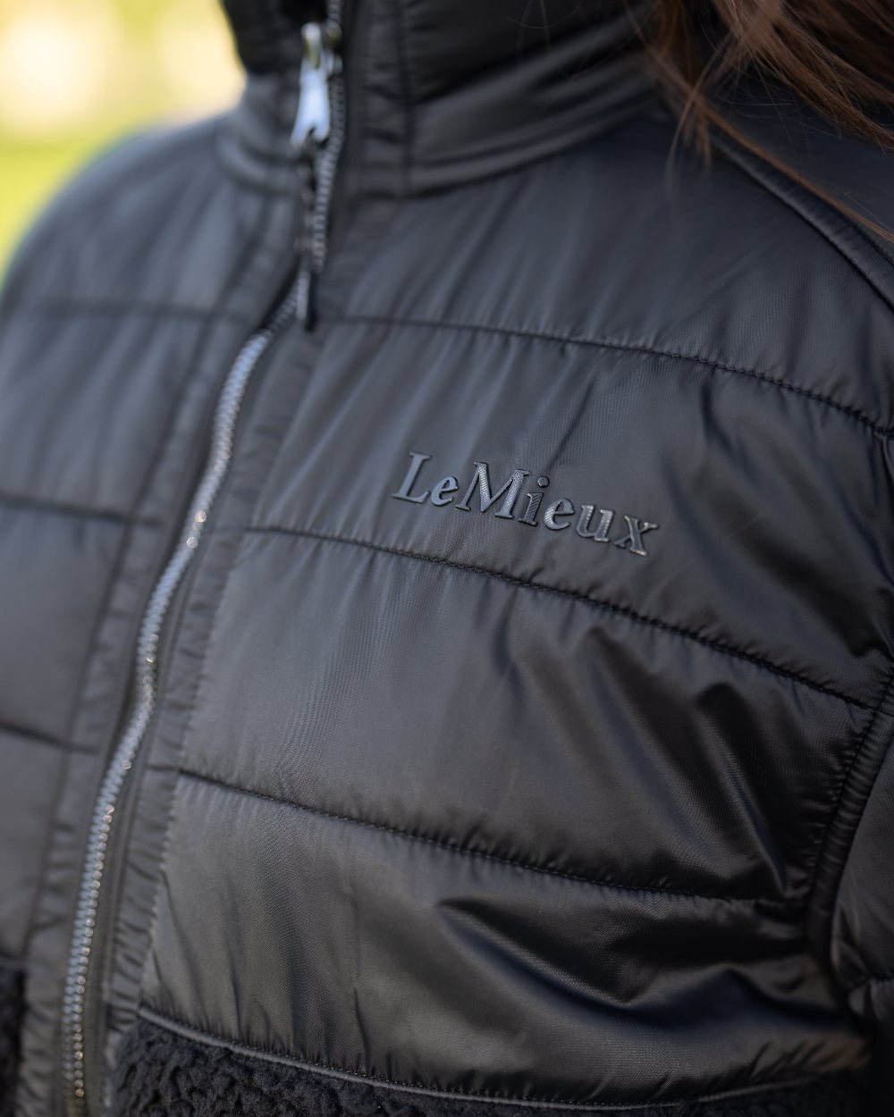 Black Coloured LeMieux Alissa Hybrid Fleece Jacket On A Front Yard Background 