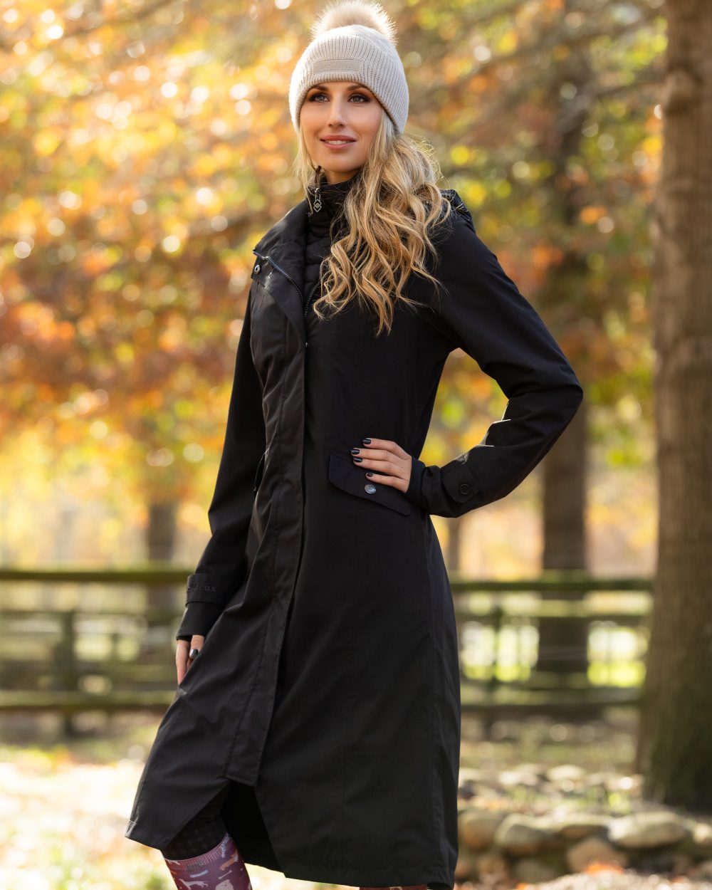 Black Coloured LeMieux Amelie Lightweight Waterproof Riding Coat On A Outer Yard Background 