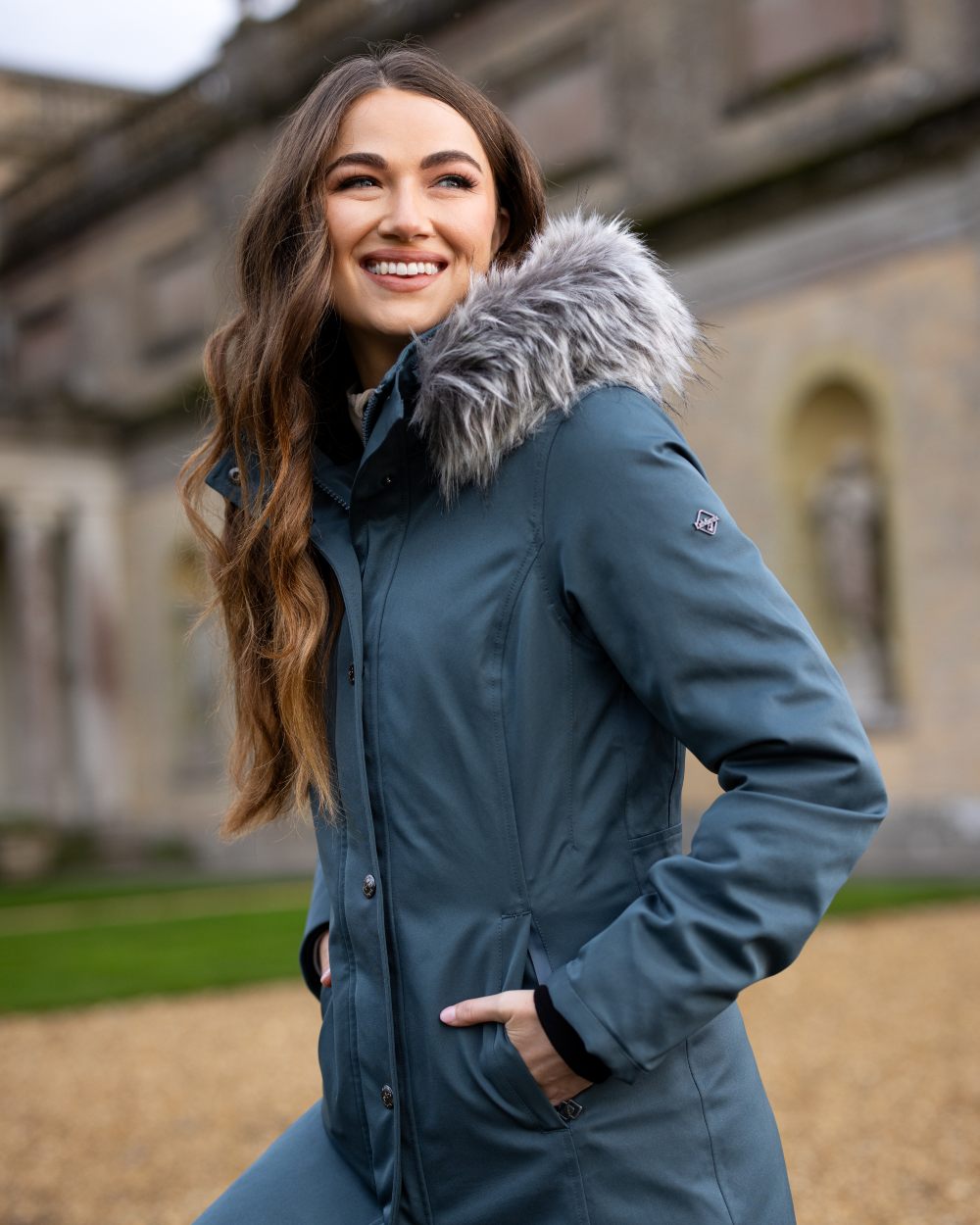 Petrol Coloured LeMieux Anya Waterproof Riding Coat On A Front Yard Background 