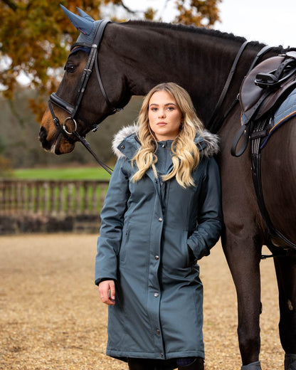 Petrol Coloured LeMieux Anya Waterproof Riding Coat On A Front Yard Background 