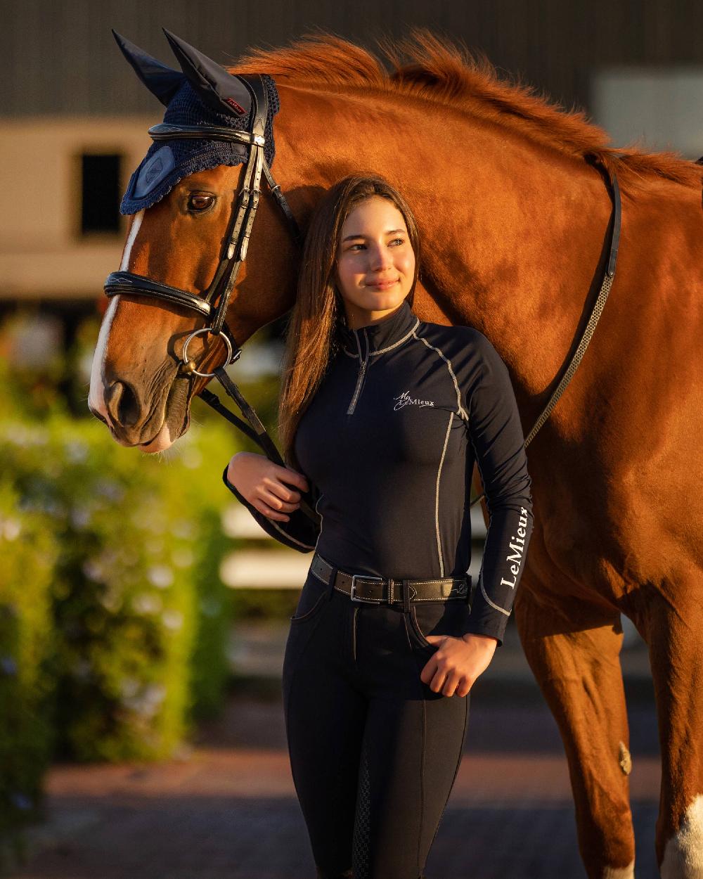 Navy coloured LeMieux Base Layer with horse in background 