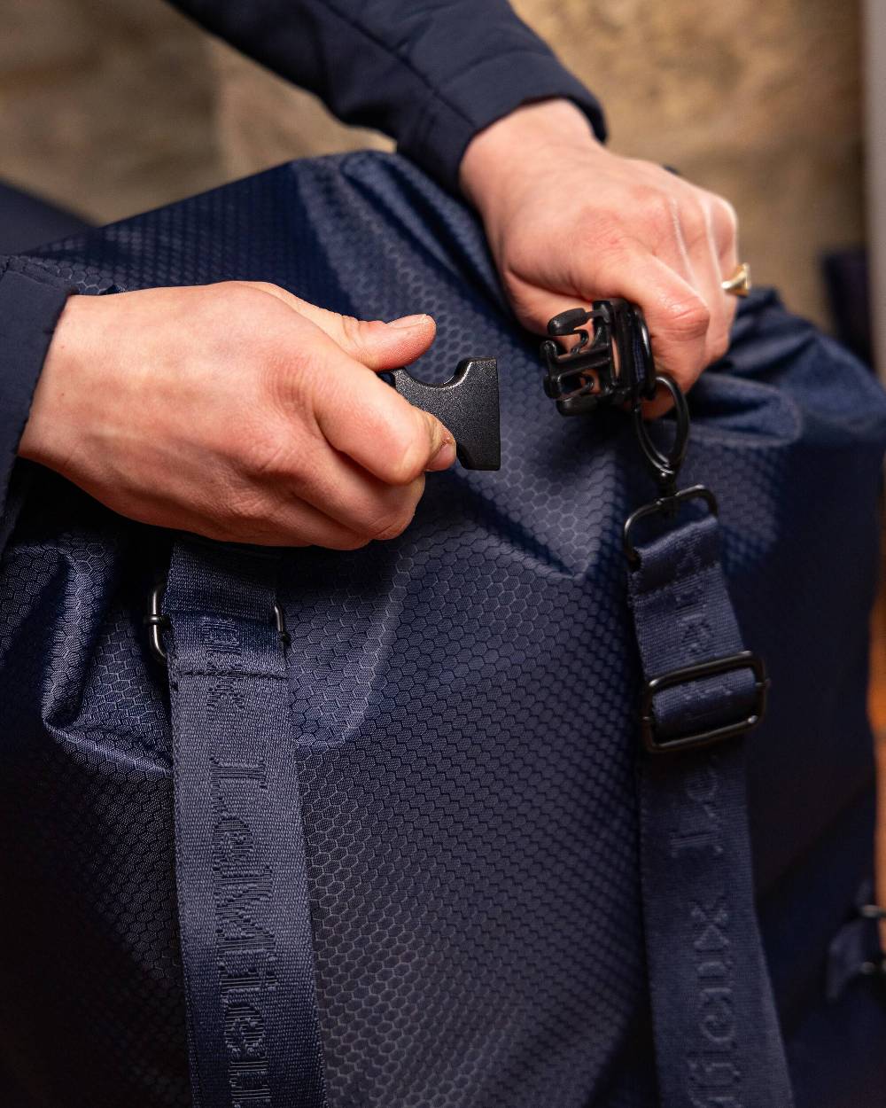 Navy coloured LeMieux Carry All Backpack on blurry background 