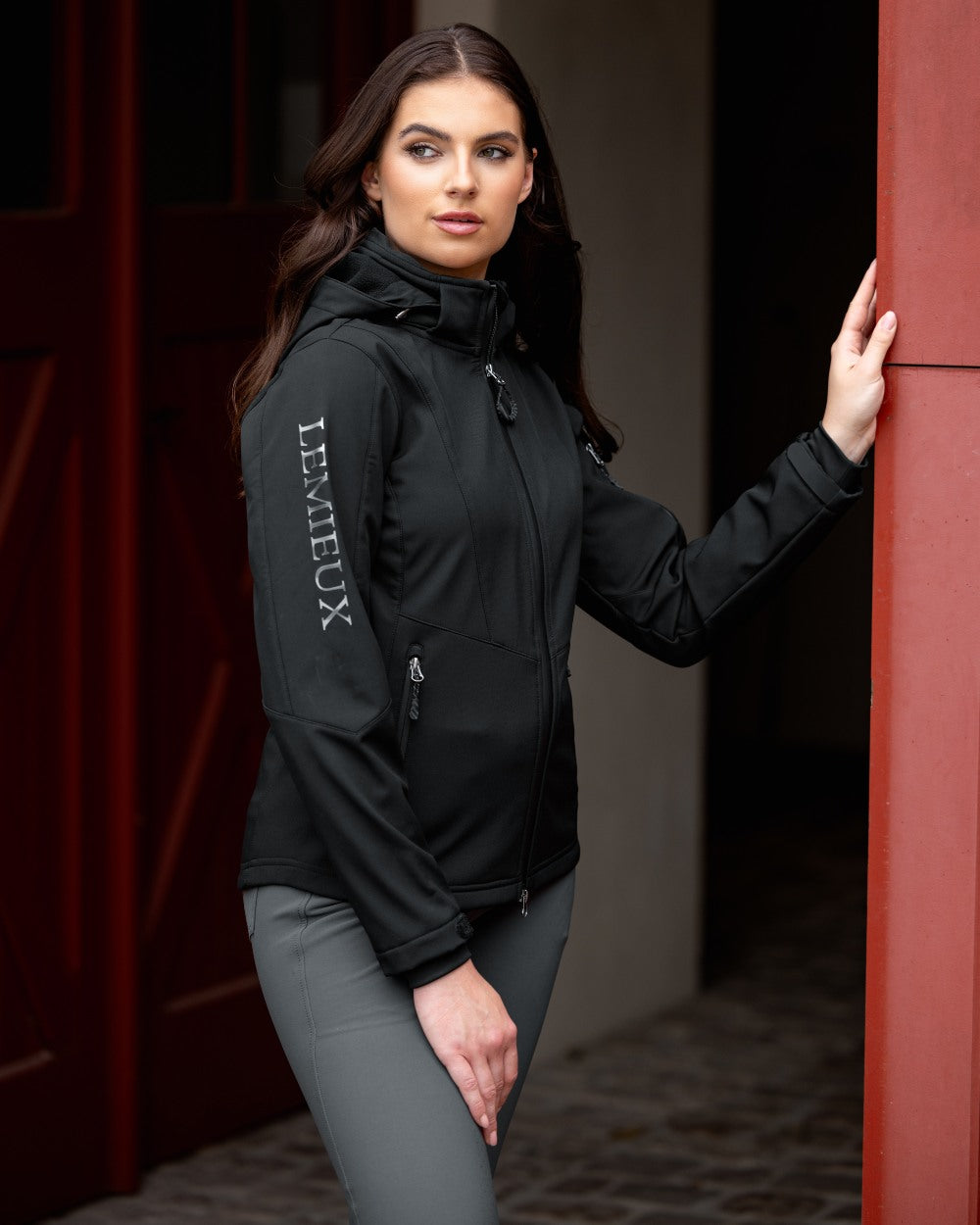 Black coloured LeMieux Celine Softshell Jacket on barn background 
