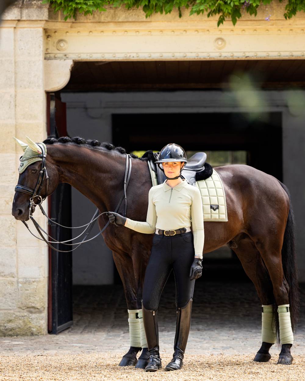 Black coloured LeMieux Demi Pull On Breggings Full Seat with horse in background 