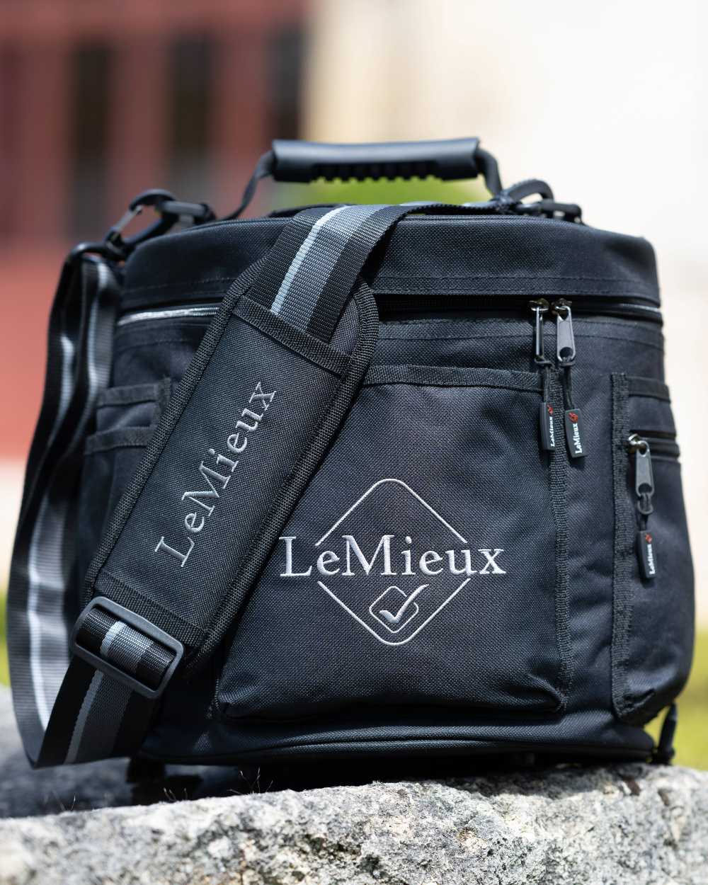 Black coloured LeMieux Elite Circular Grooming Tote on rock background 