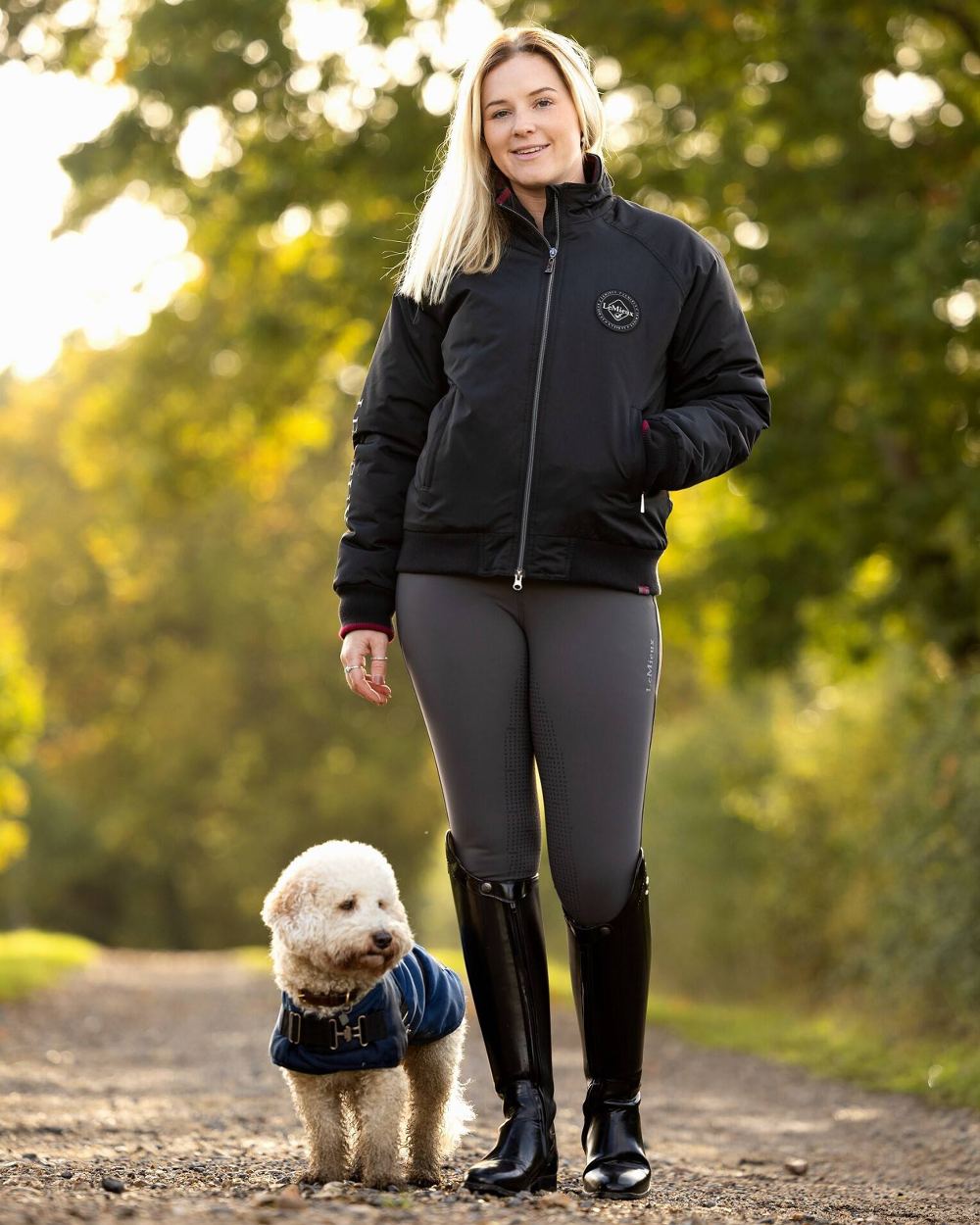 Black coloured LeMieux Elite Crew Jacket with tress in background 