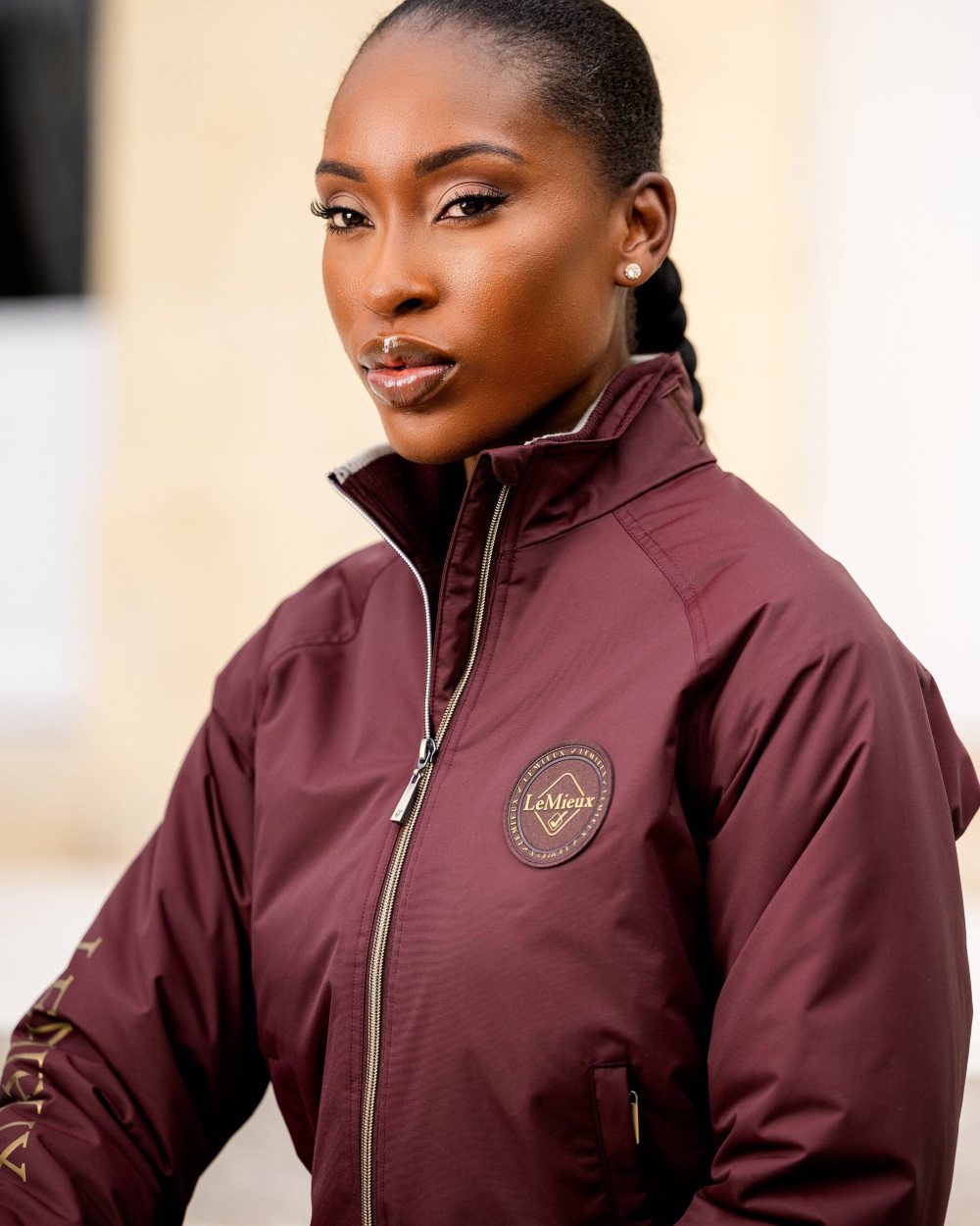 Burgundy coloured LeMieux Elite Crew Jacket on blurry background 