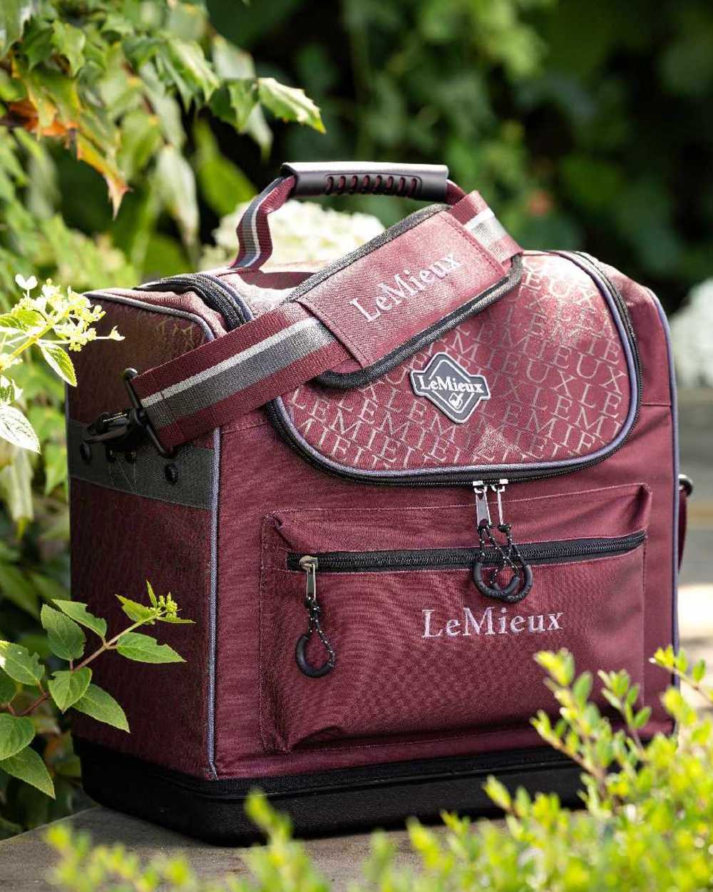 Burgundy coloured LeMieux Elite Pro Grooming Bag on garden background 