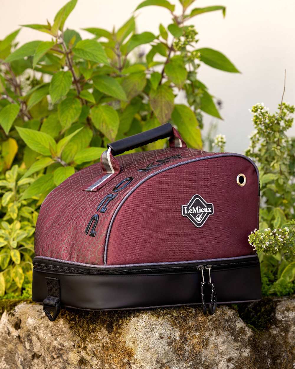 Burgundy coloured LeMieux Elite Pro Hat Box on with plants in background 