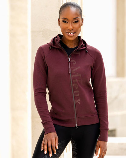 Burgundy coloured LeMieux Elite Zip Through Hoodies on blurry background 