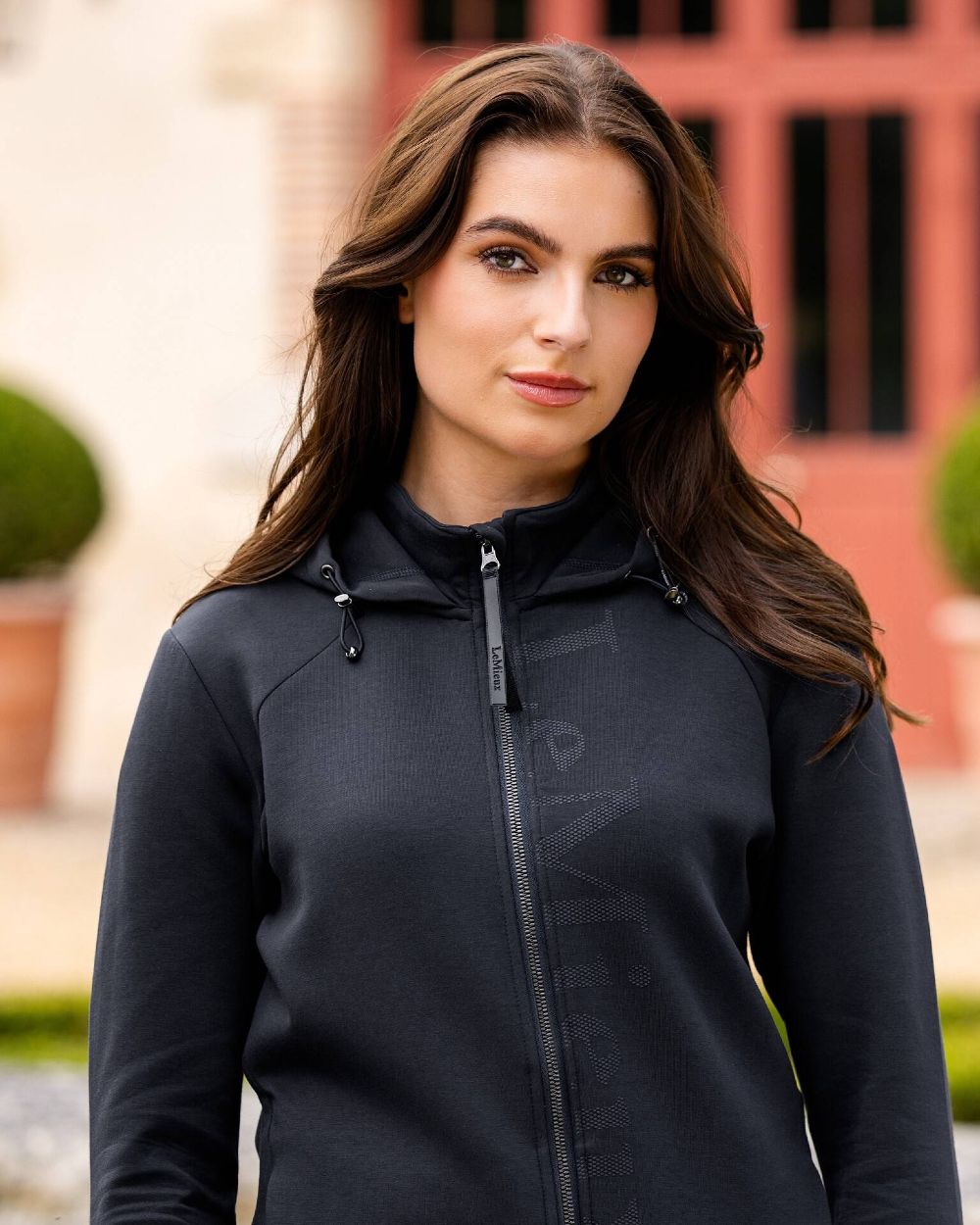 Navy coloured LeMieux Elite Zip Through Hoodies with door in background 