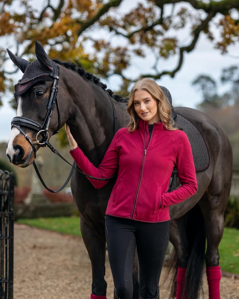 Ember Coloured LeMieux Faye Fleece Zip Through Jacket Jacket On A Front Yard Background 