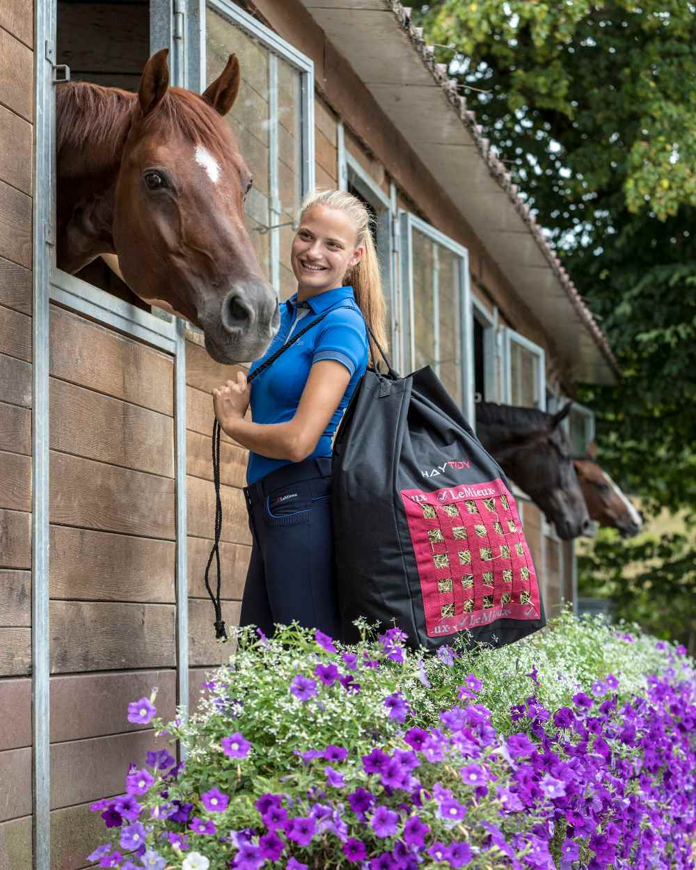 Black coloured LeMieux Hay Tidy Bag with stables in background 