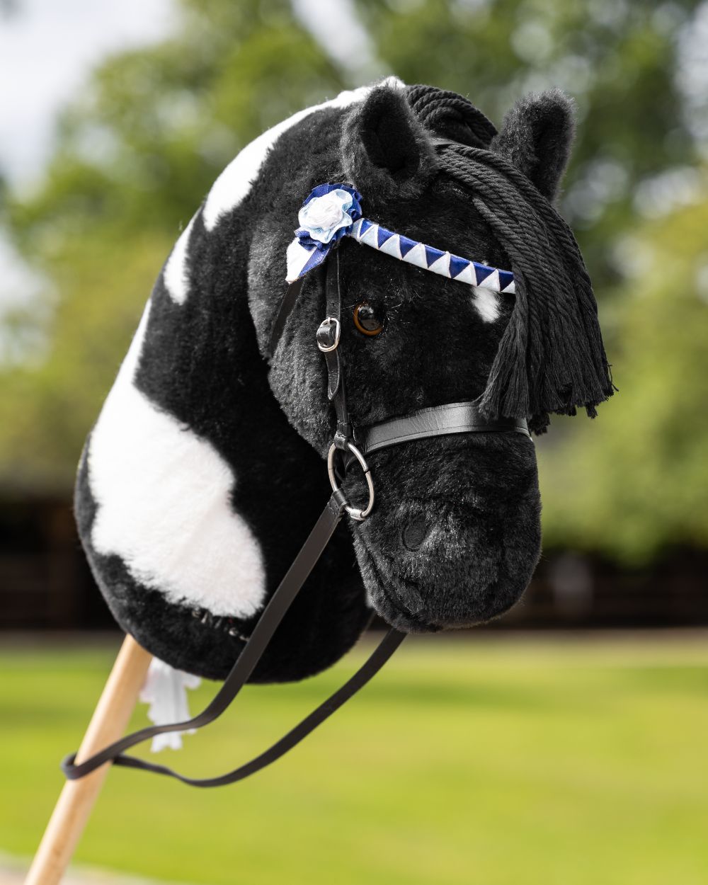 Black Coloured LeMieux Hobby Horse Showing Bridle On A Outer Yard Background